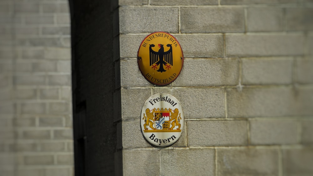 a brick wall with a coat of arms and a coat of arms on it