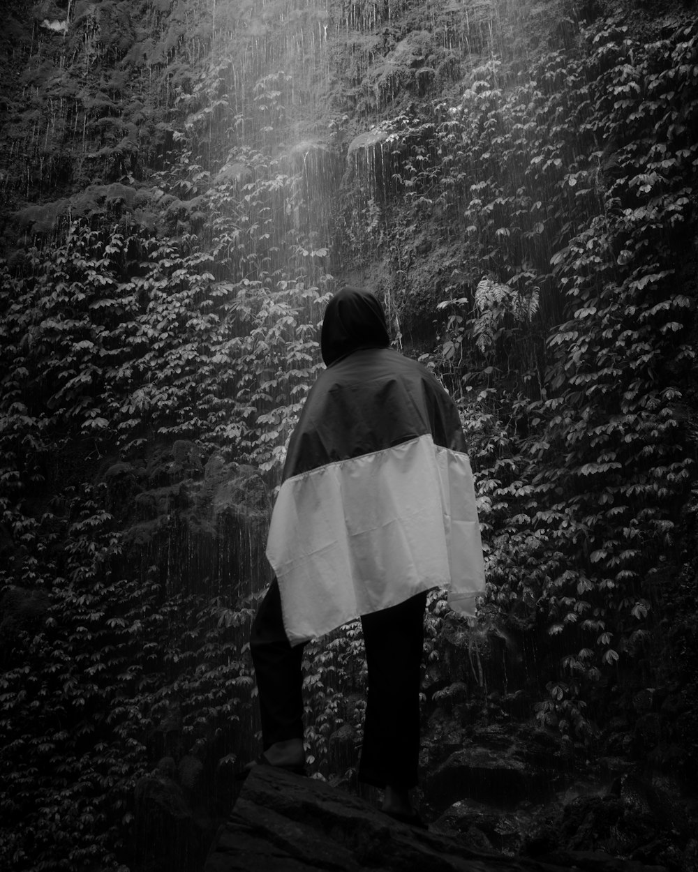 grayscale photo of woman in white jacket and black pants standing on water