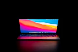 Laptop screen displaying a vibrant, colorful desktop against a dark mode background.