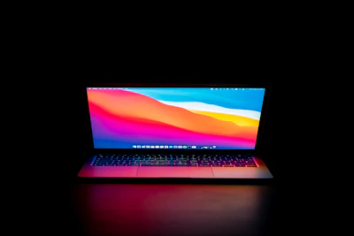 Laptop screen displaying a vibrant, colorful desktop against a dark mode background.