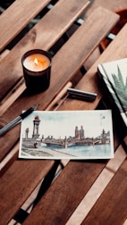 A journal, pen, and calming candle on a wooden table inviting reflection.