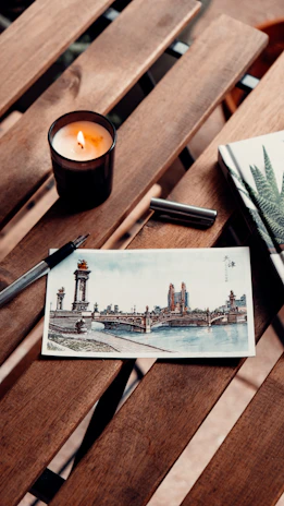A journal, pen, and candle on a wooden table, inviting self-reflection and spiritual exploration.