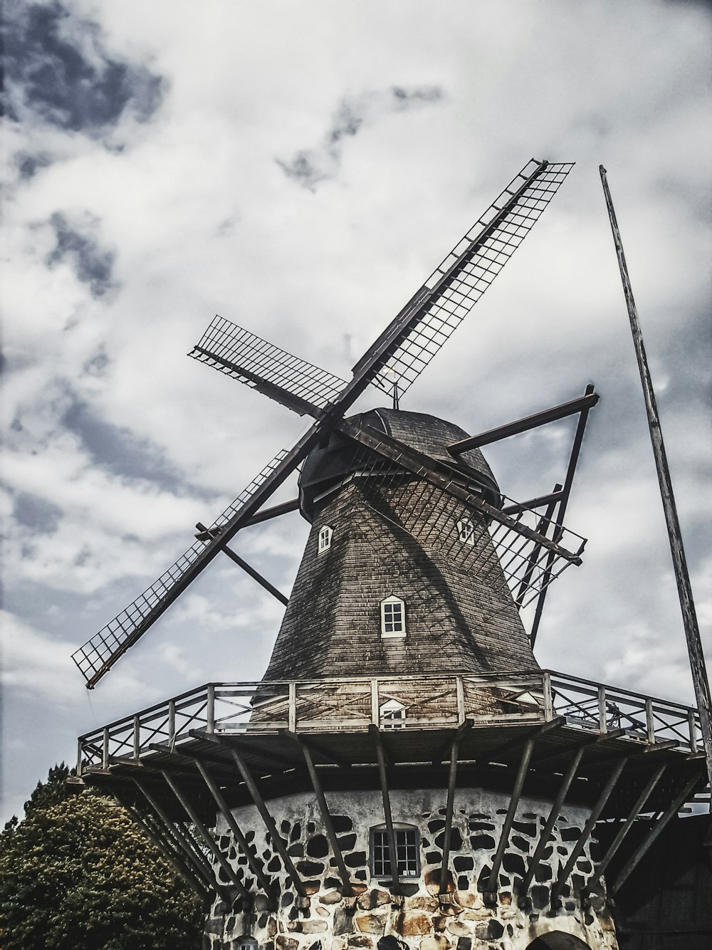 brown and black windmill under white clouds and blue sky during daytime