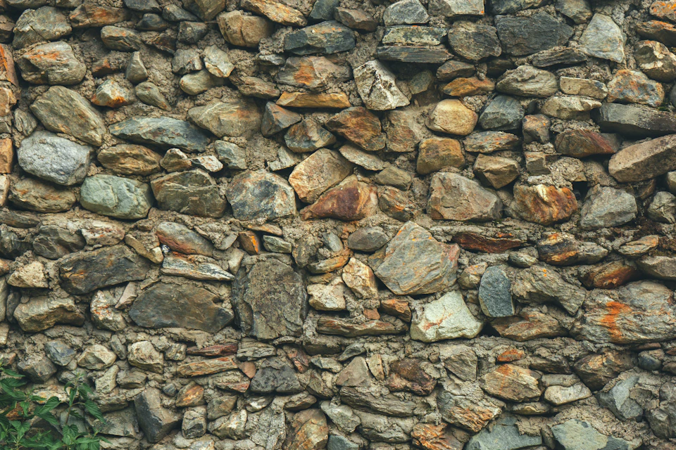 Close-up view of large, irregularly shaped rocks forming a textured and rugged stone wall