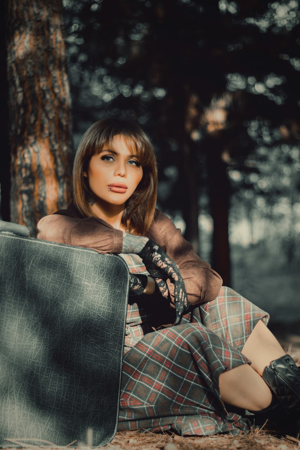 woman in brown and white plaid long sleeve shirt holding black leather bag