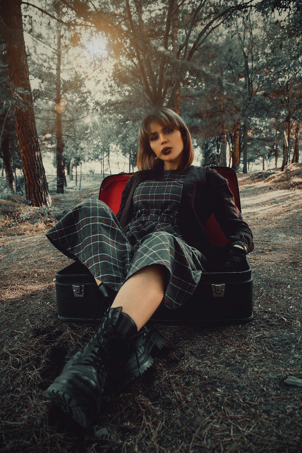 woman in black leather jacket sitting on black luggage