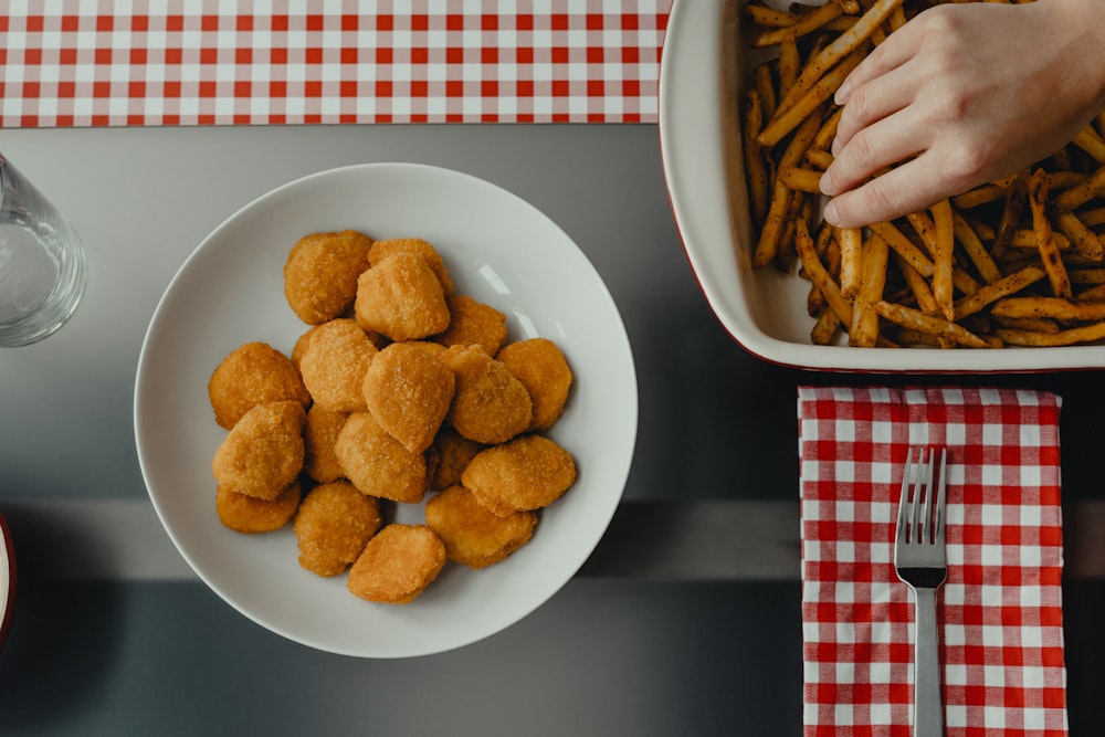 aliments frits sur assiette en céramique blanche