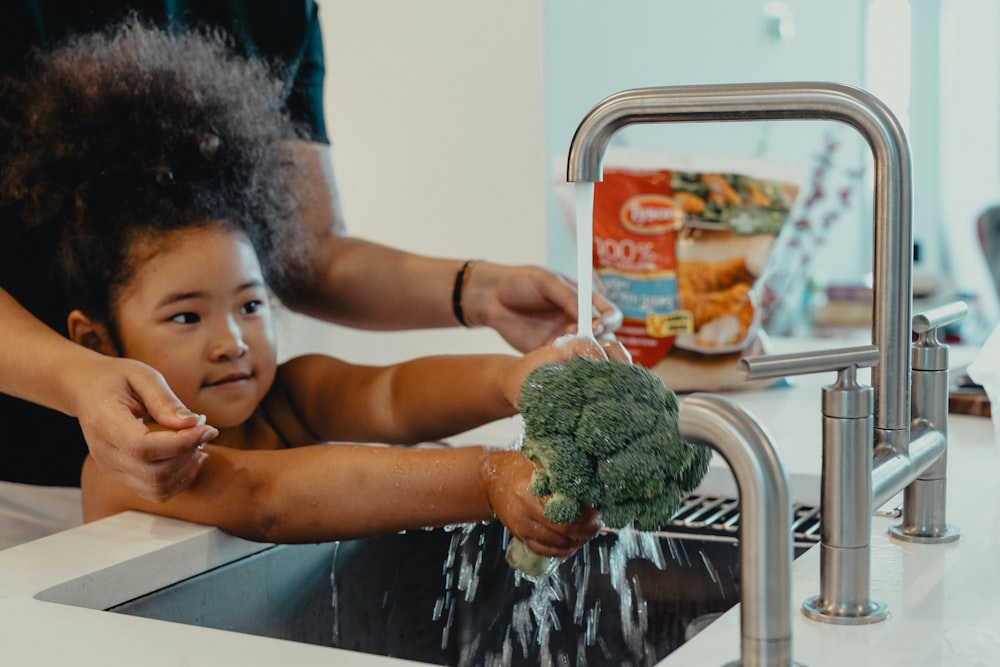 girl holding green kush on stainless steel sink