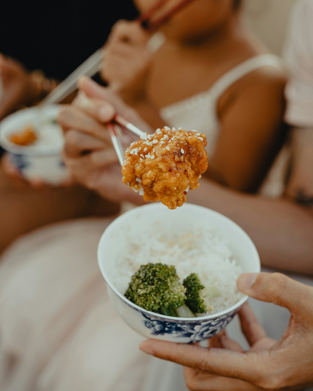 woman in white tank top holding spoon with rice