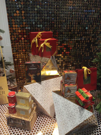A festive corporate hamper beautifully wrapped with silver and navy packaging, showcasing eco-friendly gifts inside.