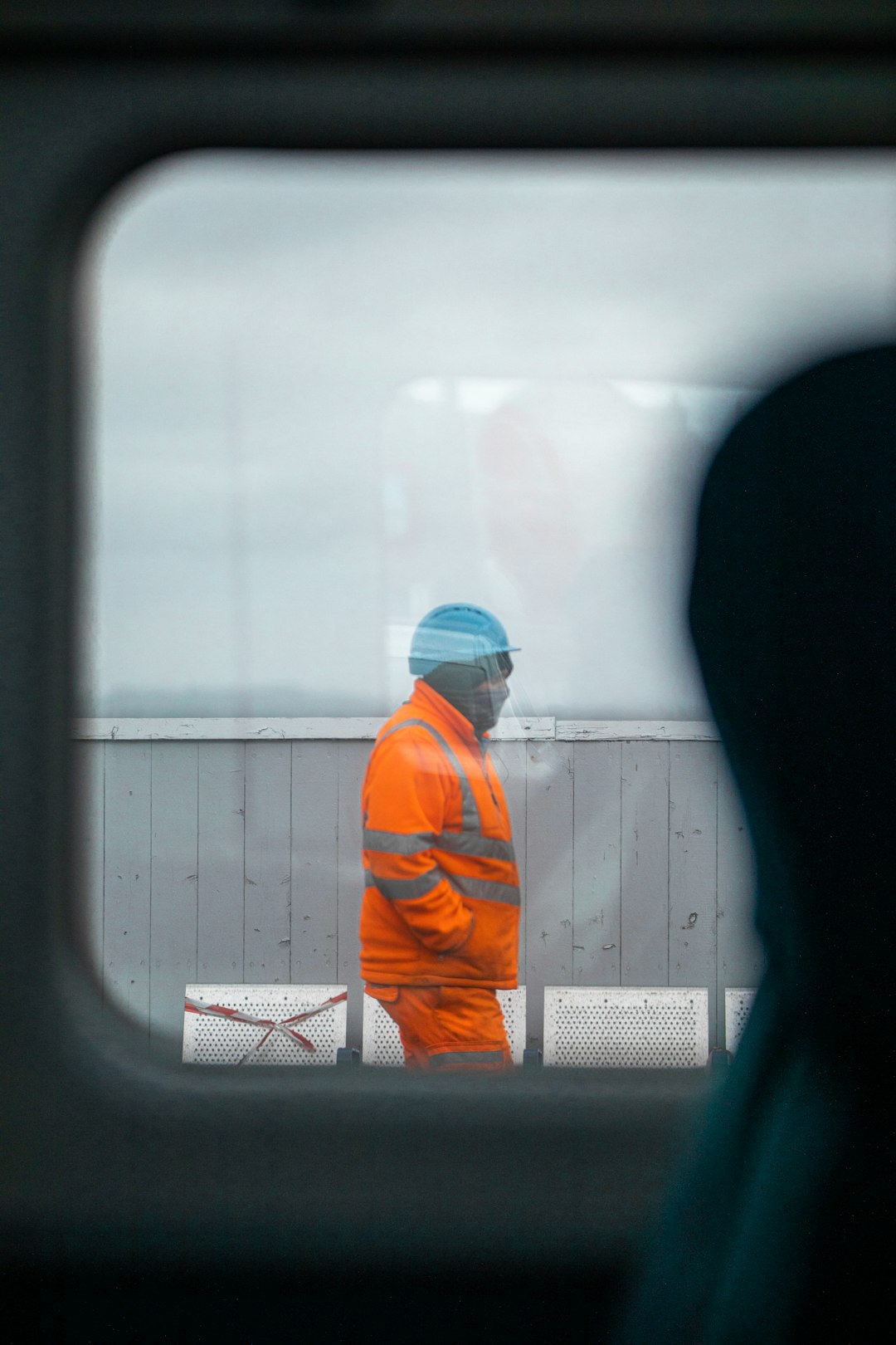 man in orange jacket and blue knit cap