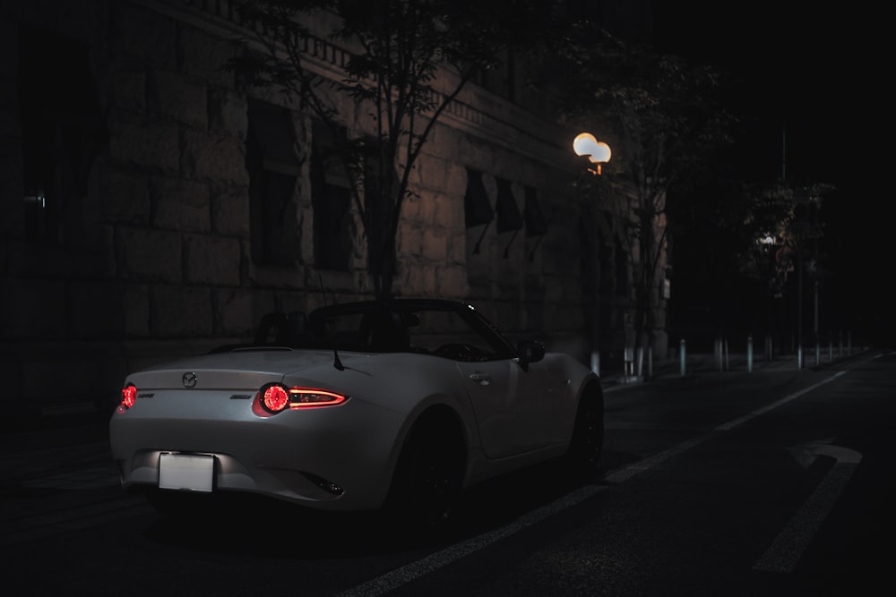 white porsche 911 parked on sidewalk during night time