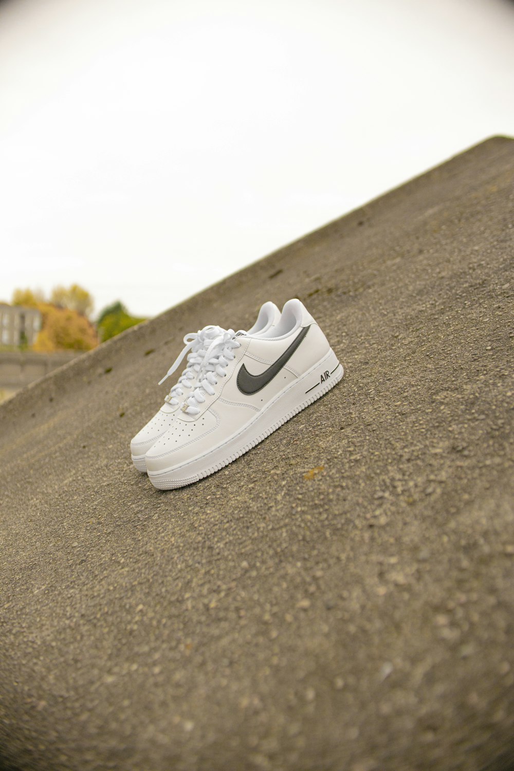 white nike air force 1 low on gray asphalt road during daytime