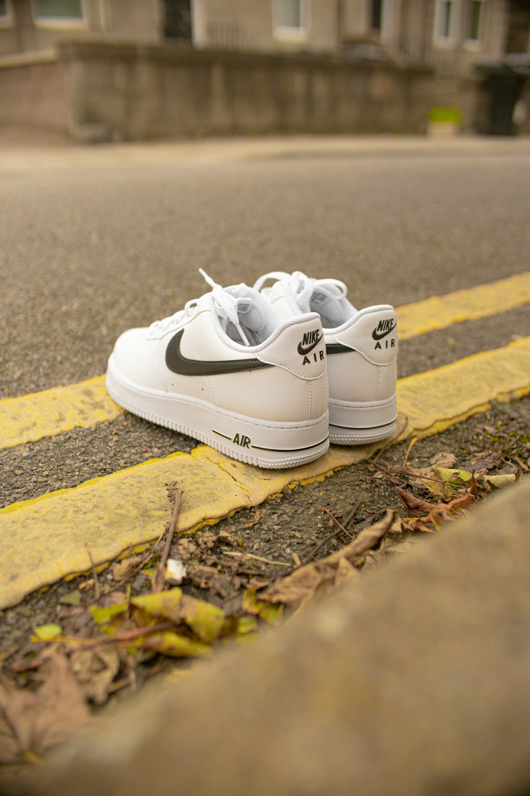white nike athletic shoes on brown soil