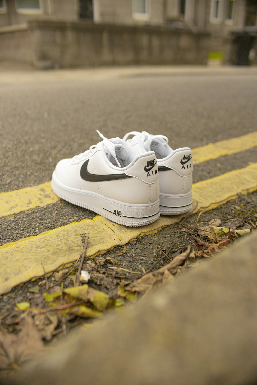 white nike athletic shoes on brown soil