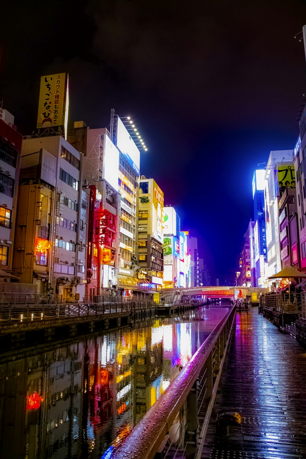 city buildings near body of water during night time