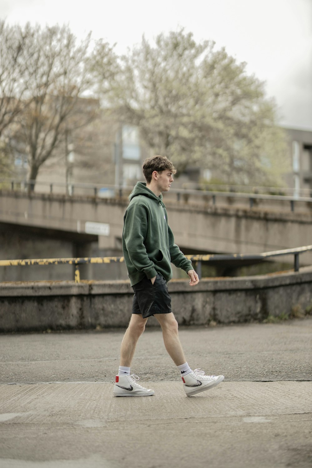 man in green jacket running on gray concrete road during daytime