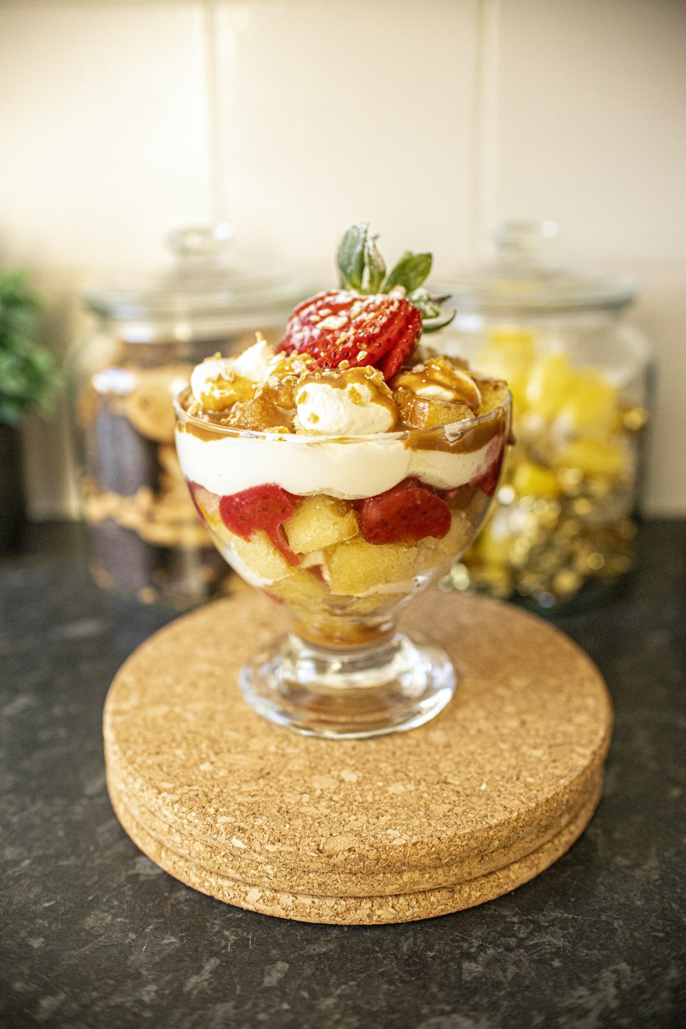 ice cream with strawberry and cream on clear glass bowl