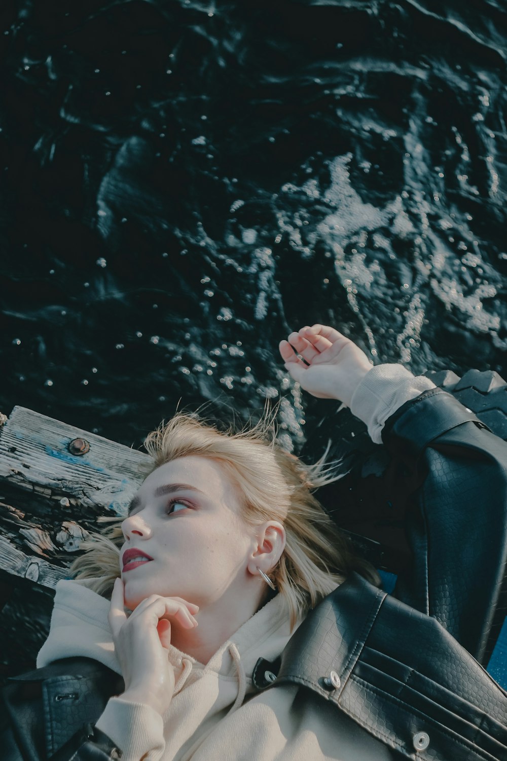 woman in black leather jacket holding her hair