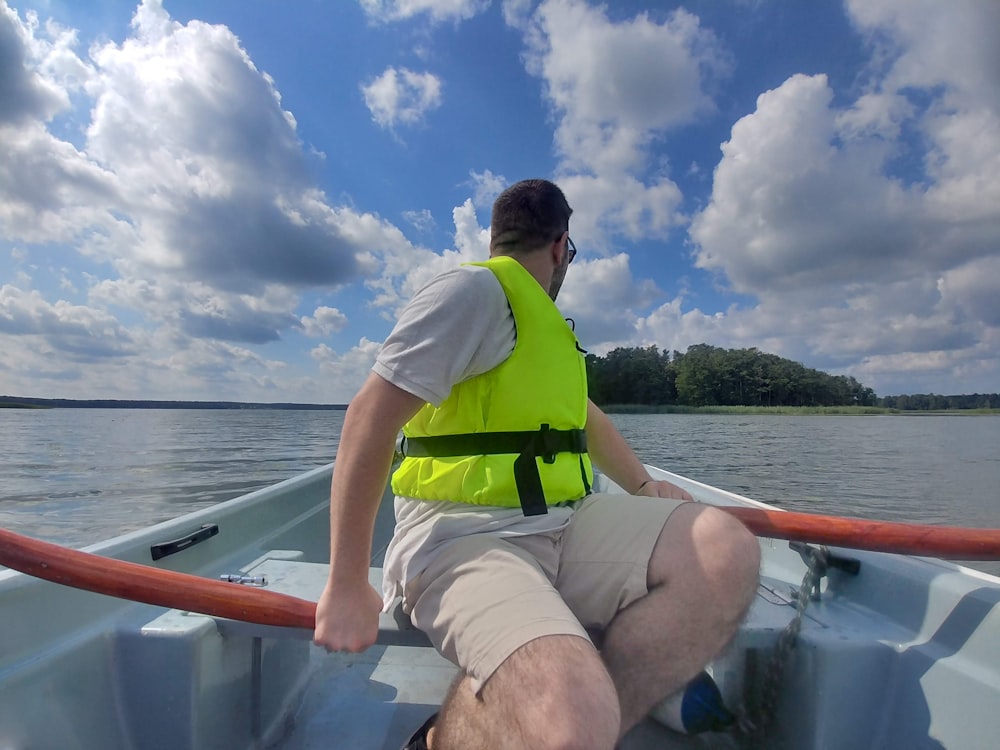 man in green shirt sitting on boat during daytime