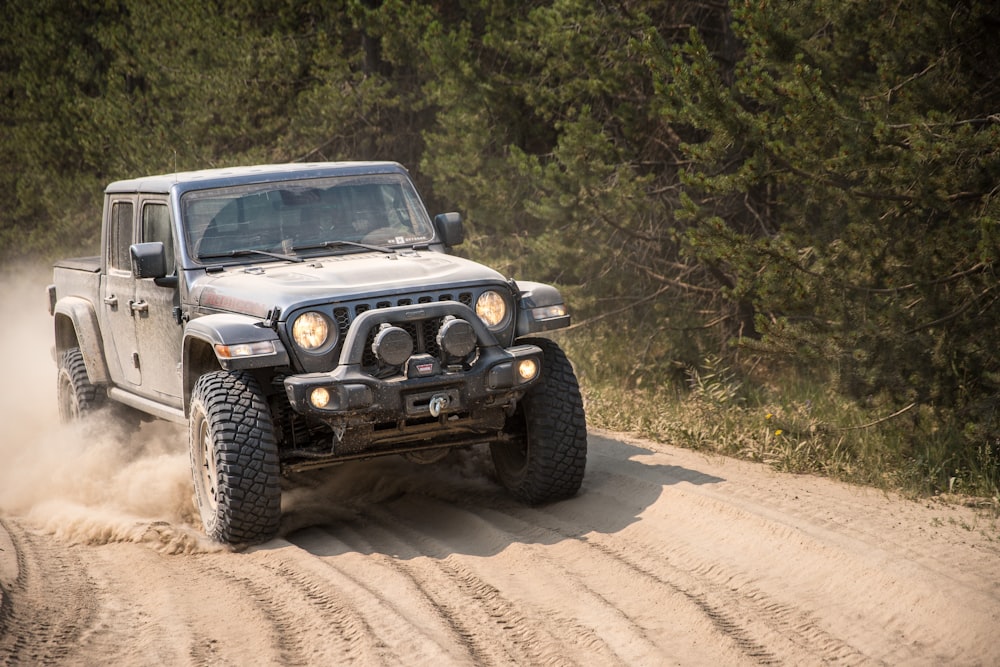 Jeep Wrangler noir et blanc sur un chemin de terre pendant la journée