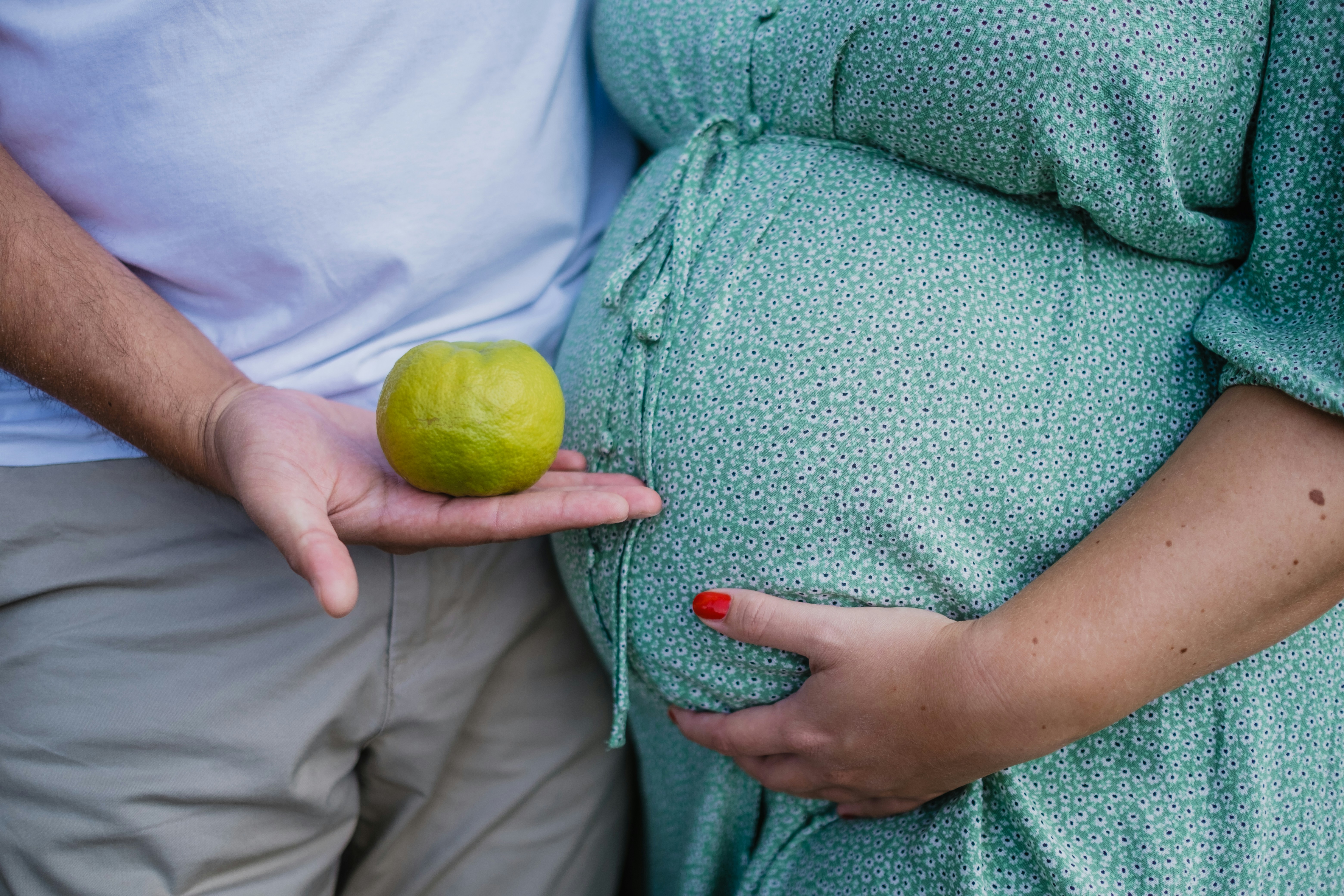 Person holding a yellow fruit illustrating healthy snack choices to stabilize blood sugar and support postpartum mood
