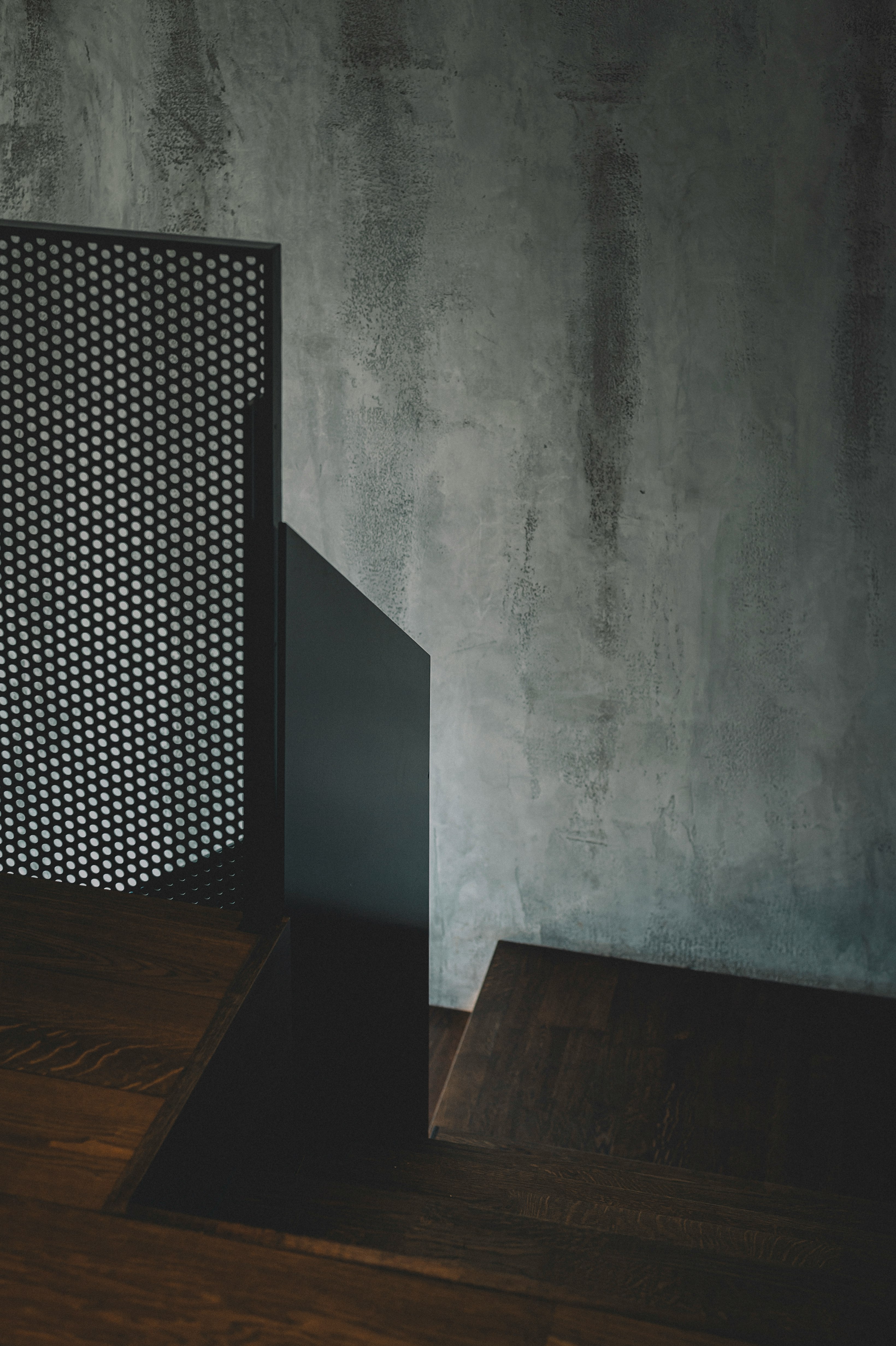 brown wooden table beside gray wall