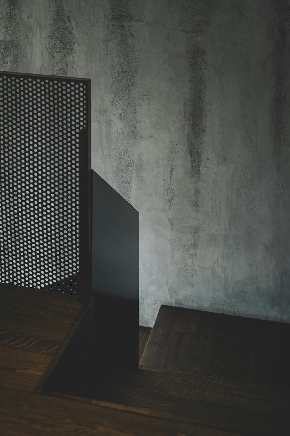 brown wooden table beside gray wall