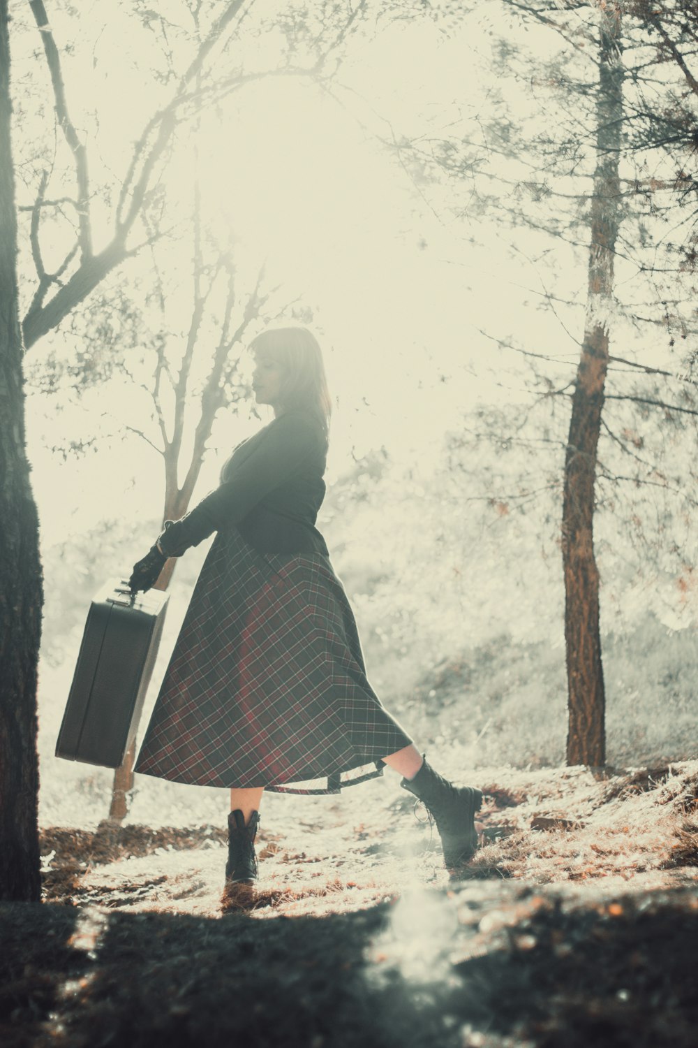 woman in black and white plaid dress standing on brown field during daytime