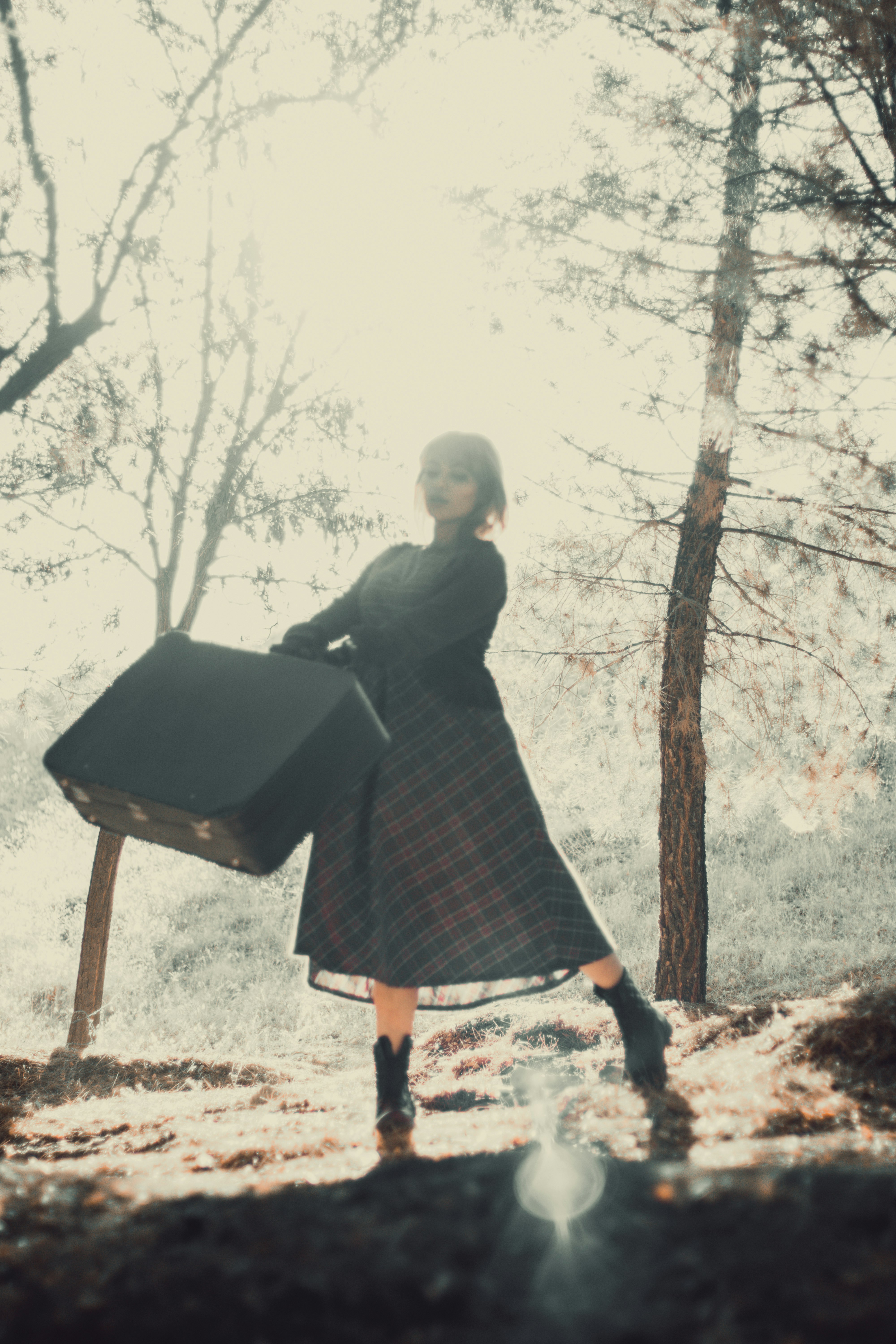 woman in black long sleeve dress standing near brown wooden table