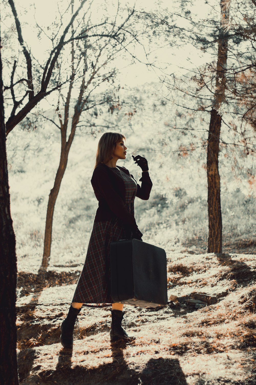 woman in black long sleeve dress standing on brown rock