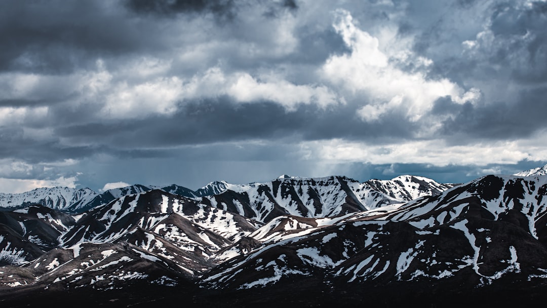 snow covered mountains under cloudy sky during daytime