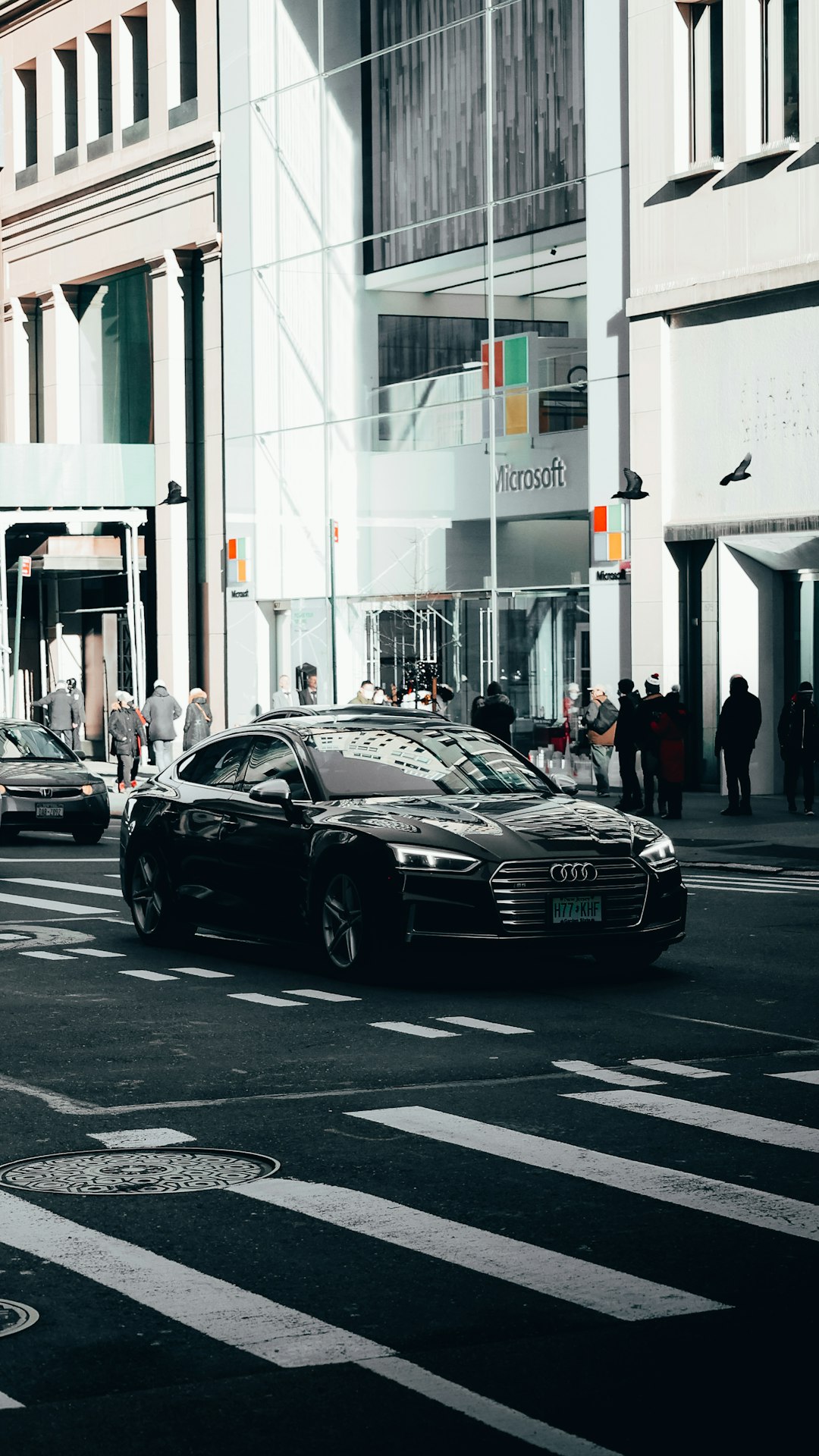 black porsche 911 parked on street near people walking on sidewalk during daytime