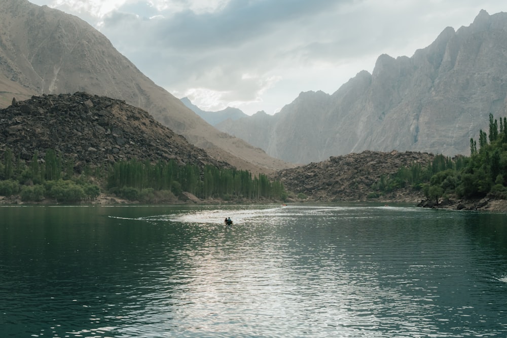 personne dans un plan d’eau près d’une montagne pendant la journée