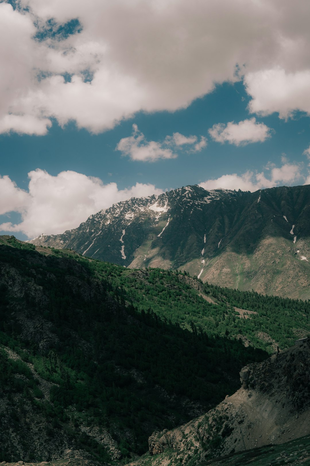 green and white mountain under blue sky and white clouds during daytime