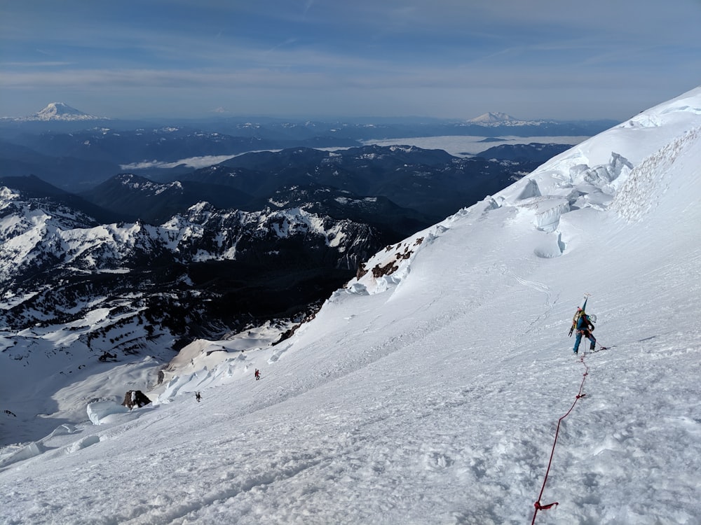 person in black jacket and red pants walking on snow covered ground during daytime