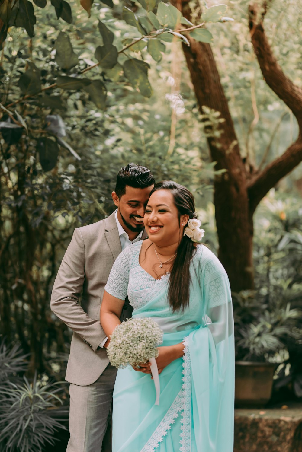 man in gray suit jacket hugging woman in teal dress