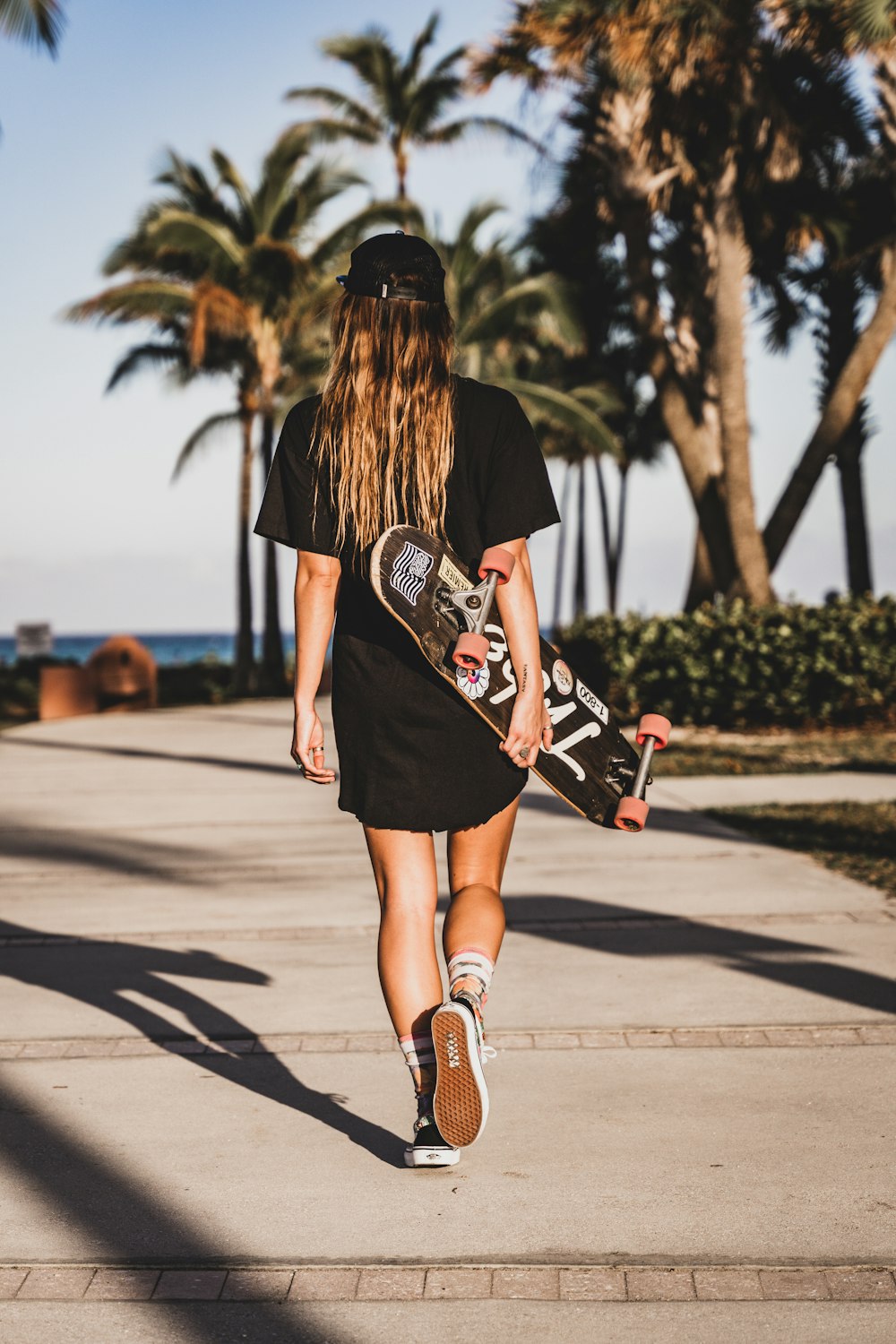 woman in black t-shirt and brown leather boots running on road during daytime