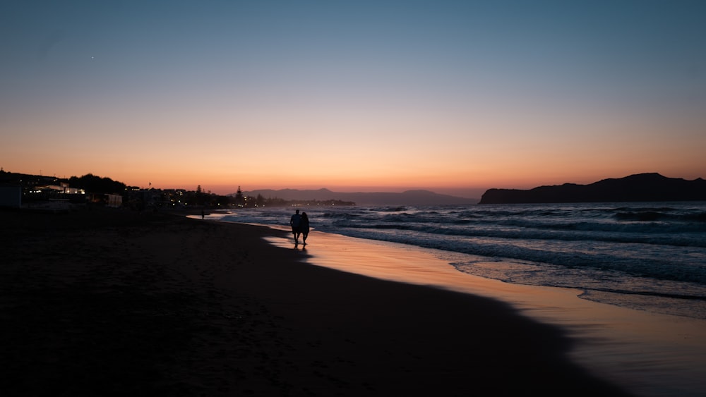 silhouette of people on beach during sunset