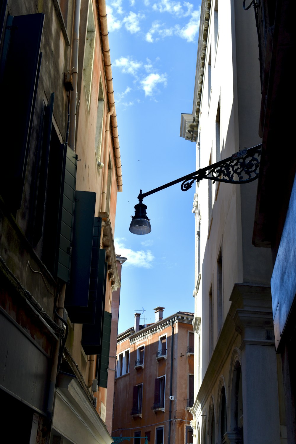 black street light near brown concrete building during daytime