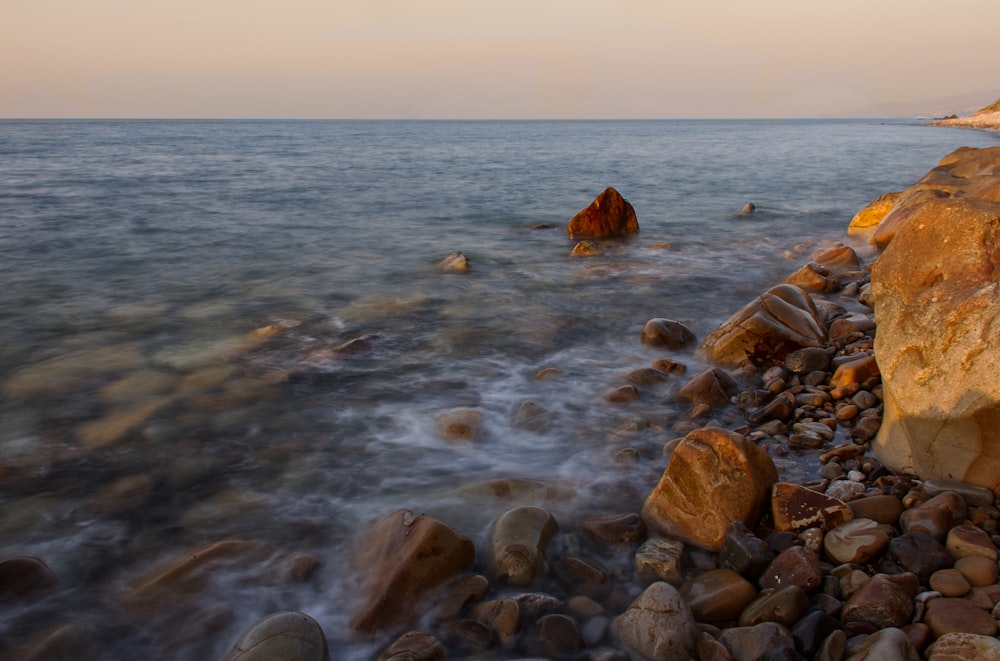 brown rocks on sea shore during daytime