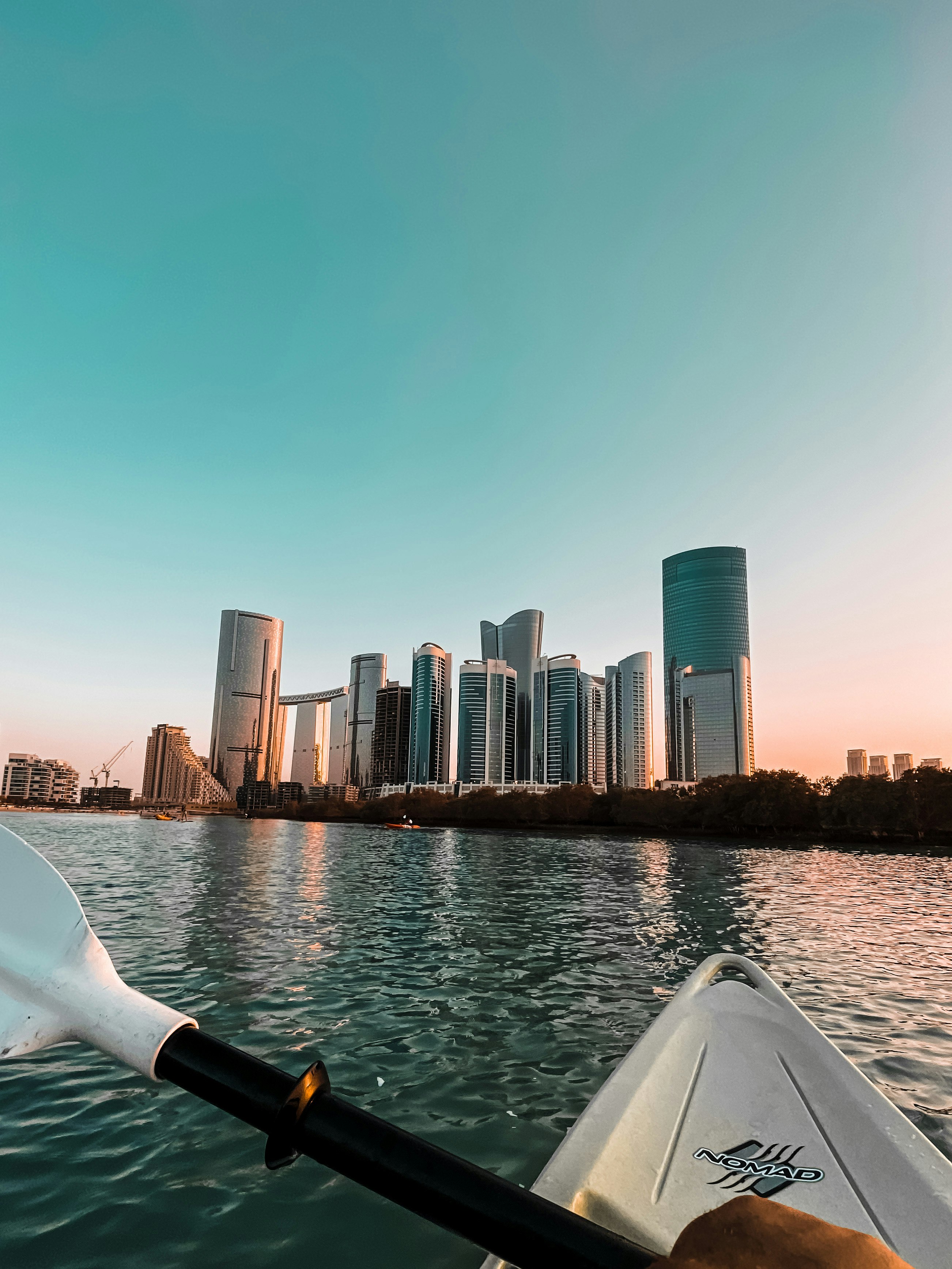 white boat on water near city buildings during daytime