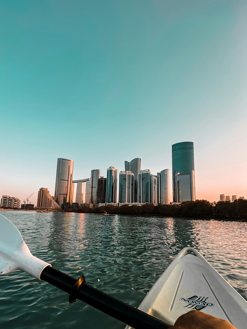 white boat on water near city buildings during daytime