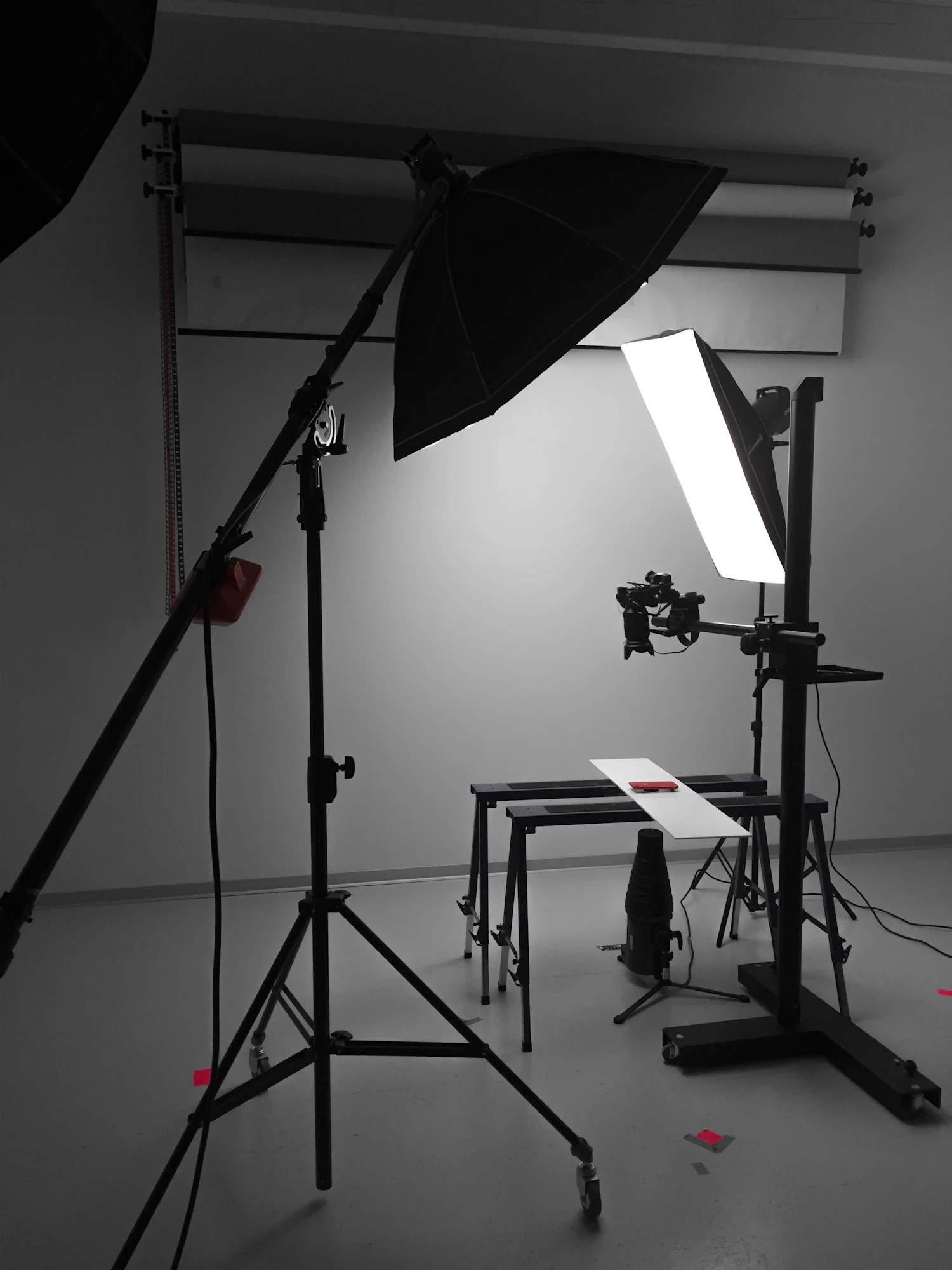 A lit studio corner with a softbox, stands and a bare seamless backdrop