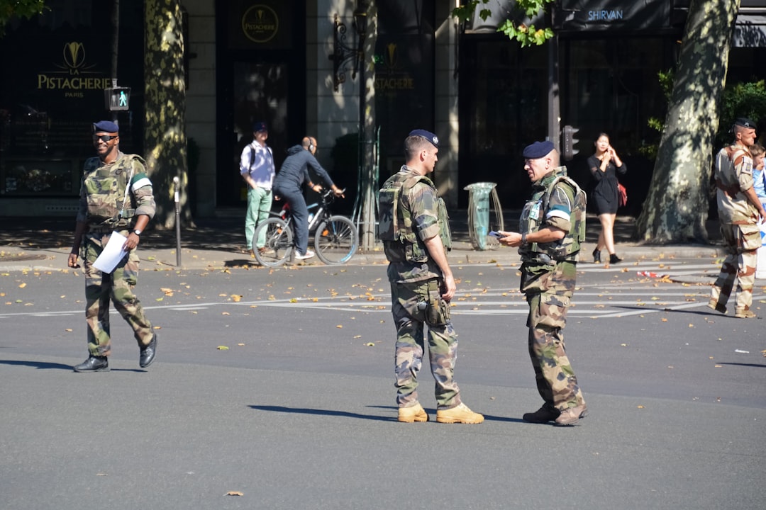 men in green and brown camouflage uniform walking on street during daytime