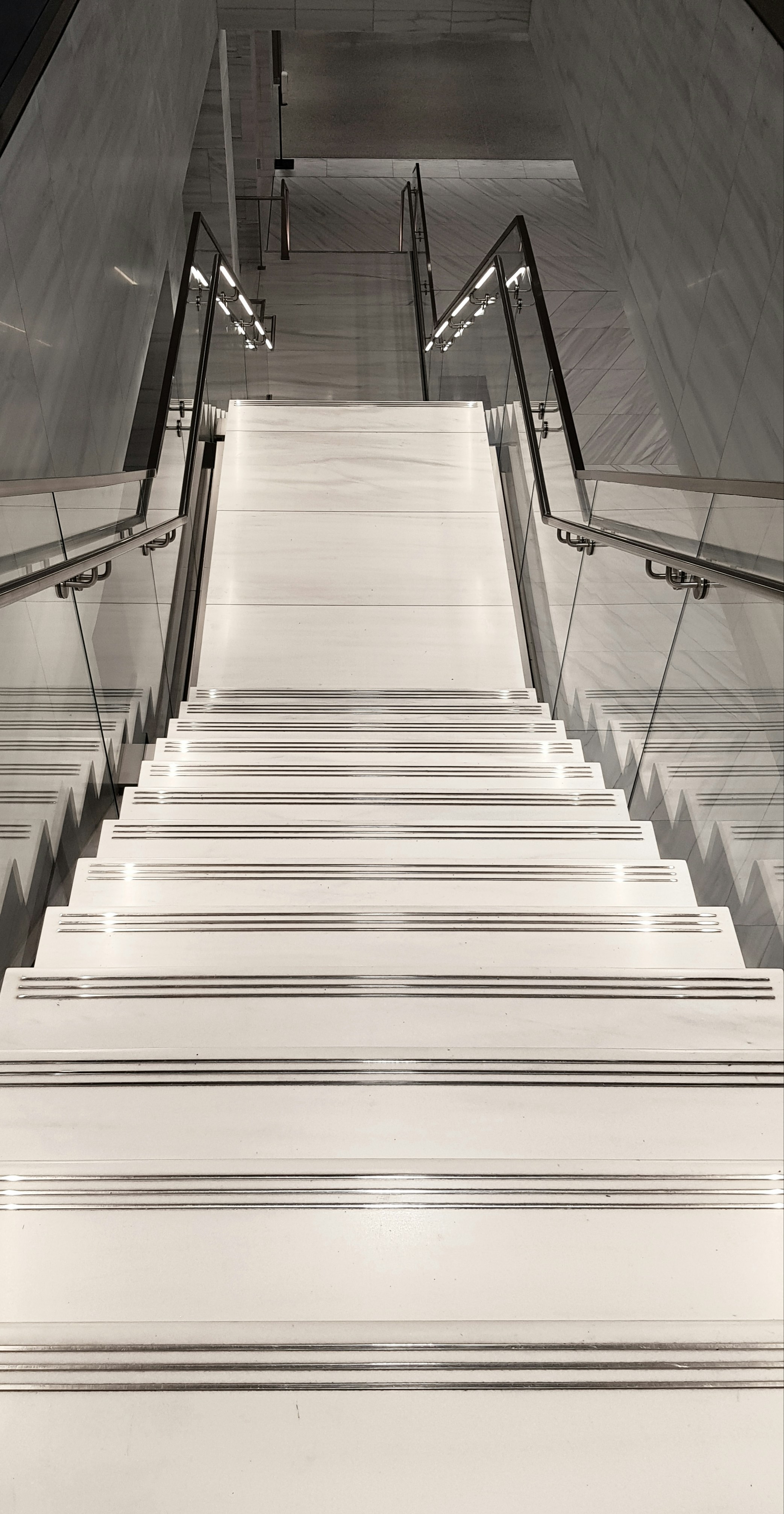 Sleek aluminum and glass balustrade on modern staircase, bright airy interior, minimalist design