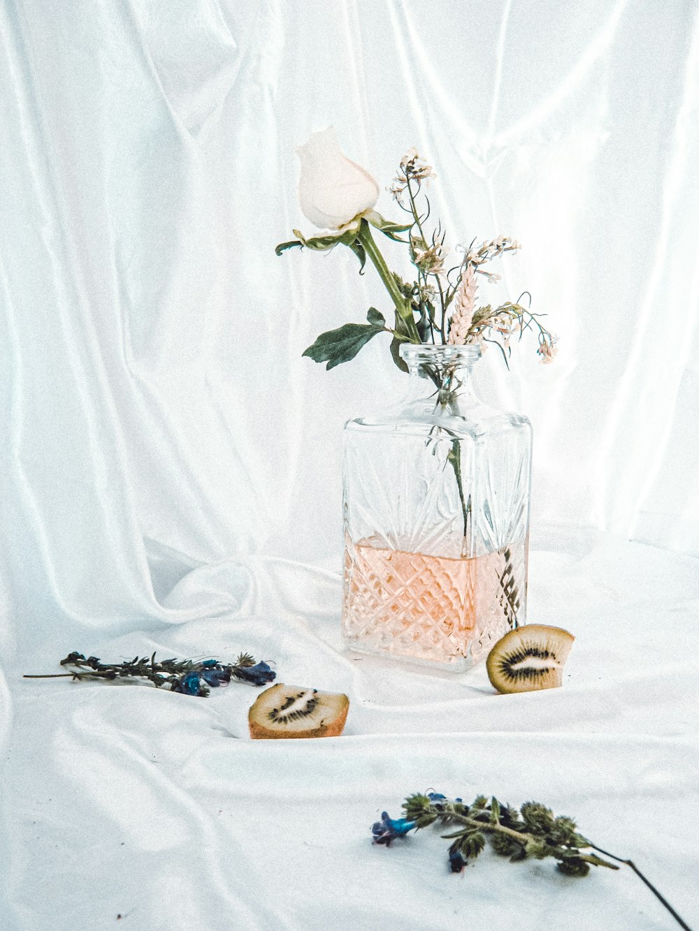 white roses in clear glass vase