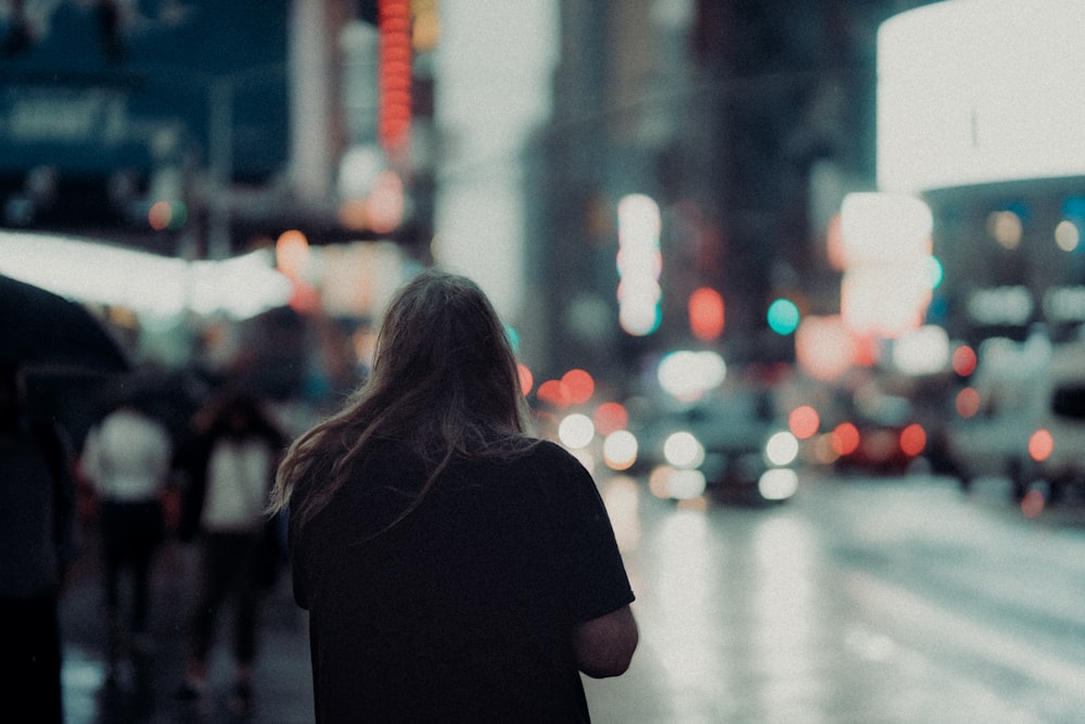 woman in black shirt standing on street during daytime