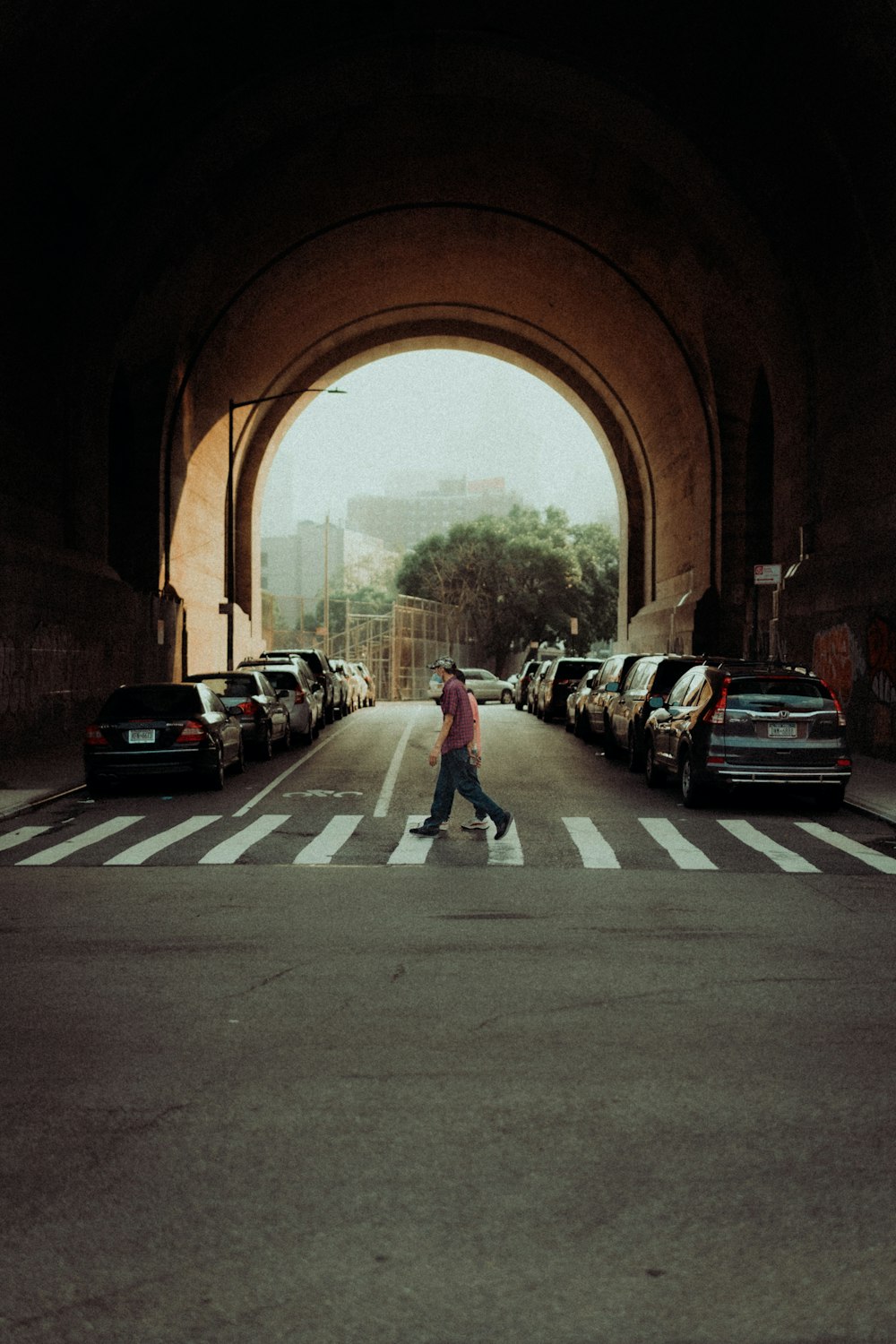 man in blue denim jeans walking on sidewalk during daytime