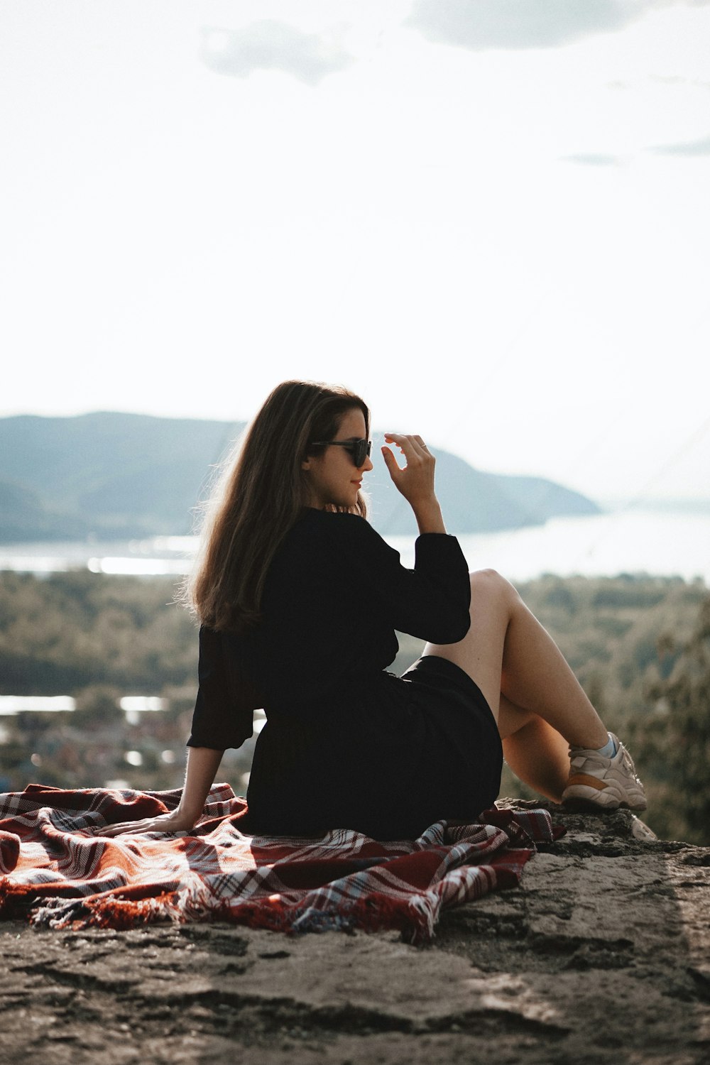 woman in black long sleeve shirt sitting on rock during daytime